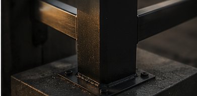 Steel fence post anchored to a concrete footing