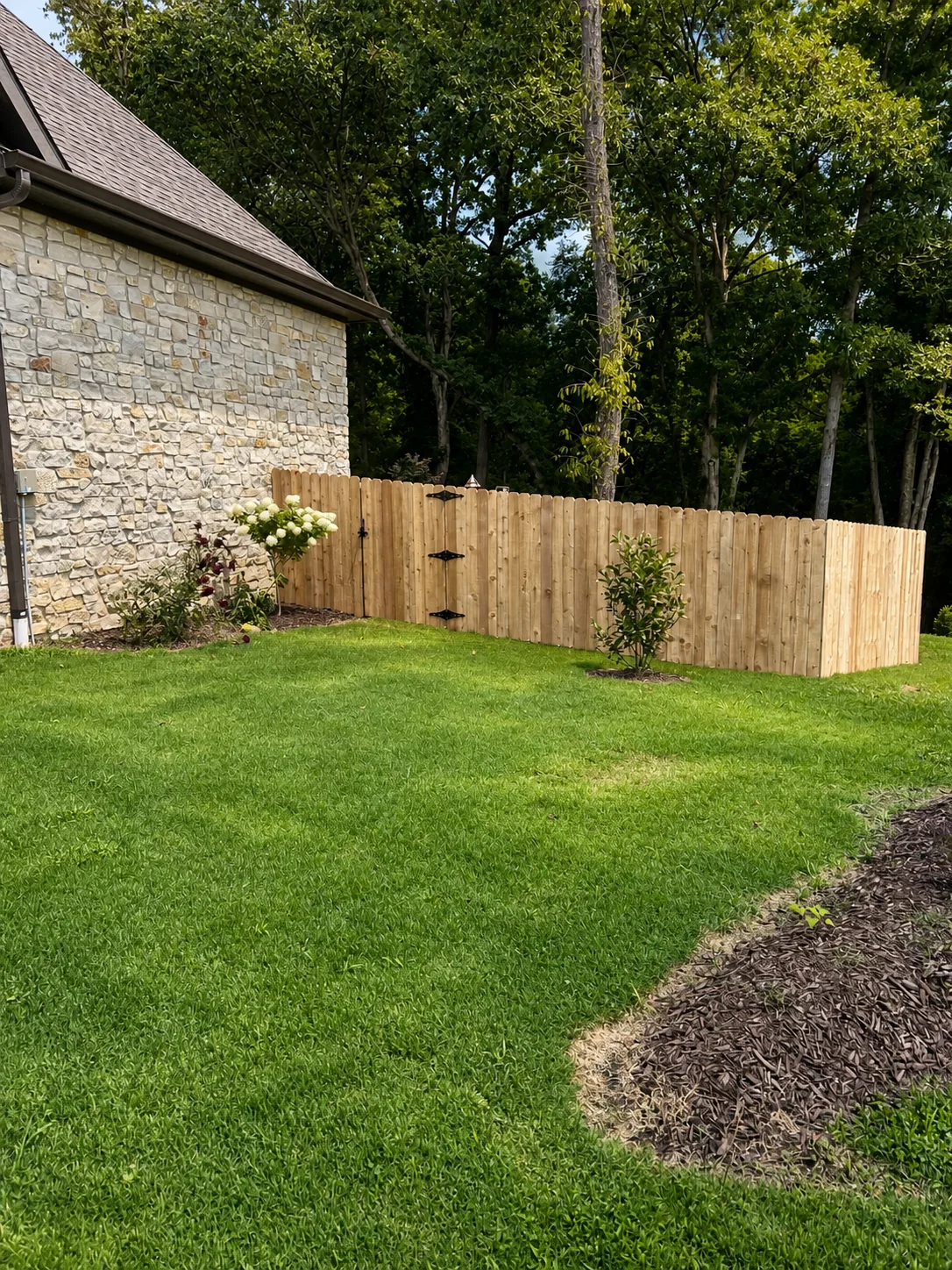 Cedar fence beside a stone home